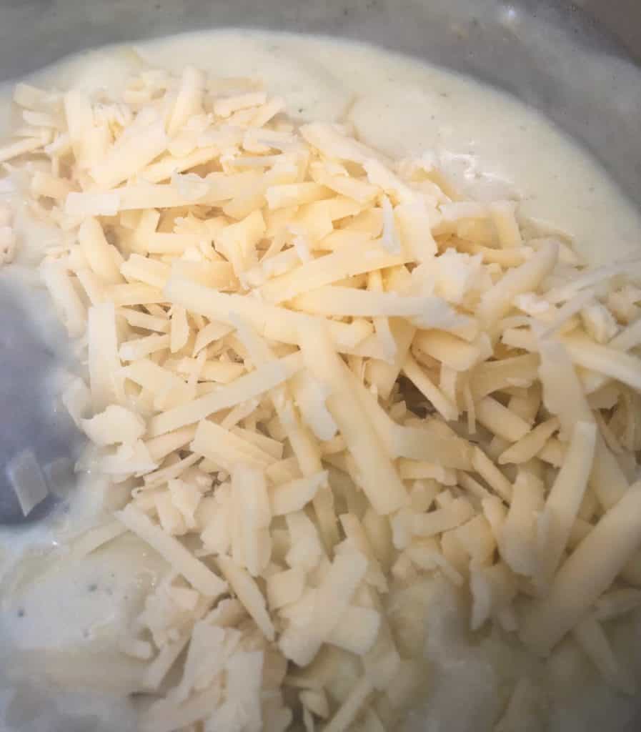 white sauce with grated cheese in pan