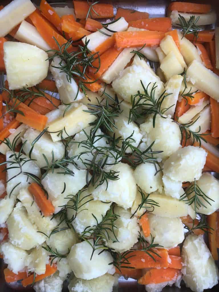 potatoes carrots parsnips rosemary in roasting tin