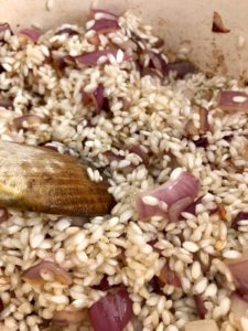 red onion and risotto rice frying in pan