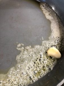 garlic bulb frying in butter