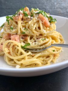 spaghetti carbonara with smoked salmon parsley parmesan in bowl