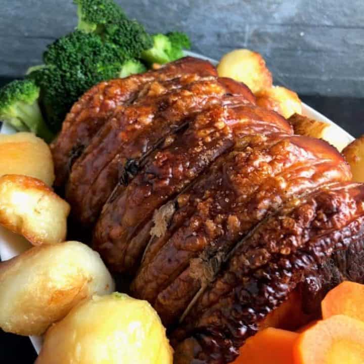 roast pork joint with roast potatoes carrots and broccoli