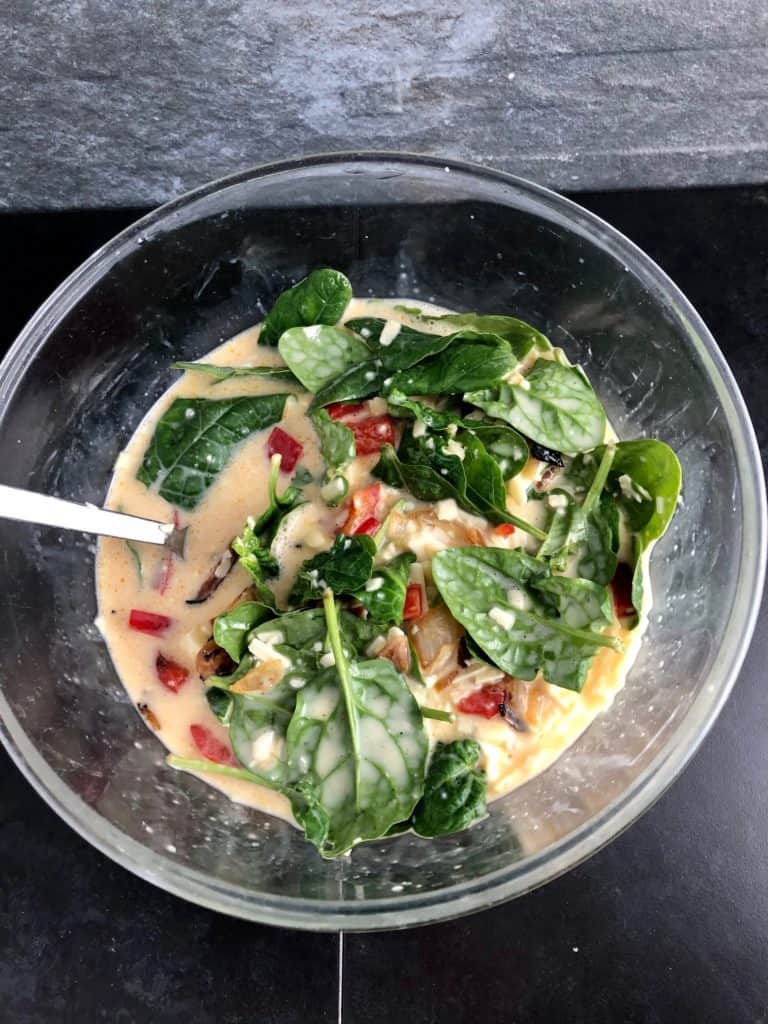 beaten egg milk cheese spinach red peppers in bowl