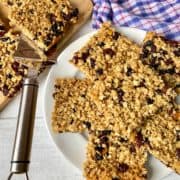 Soft Chewy Flapjacks with dried fruit cut up on plate and chopping board