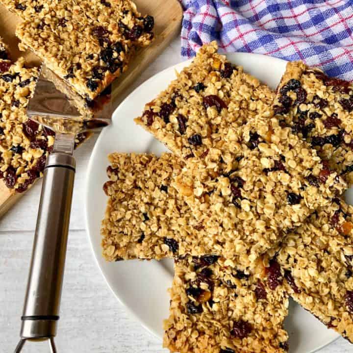 Soft Chewy Flapjacks with dried fruit cut up on plate and chopping board