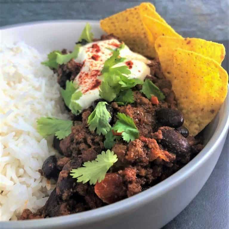 Chilli in a bowl with rice and tortilla chips