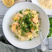 prawn and pea risotto in bowl topped with lemon zest and fresh parsley