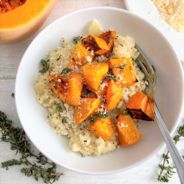 roasted butternut squash risotto in bowl topped with fresh thyme and grated parmesan