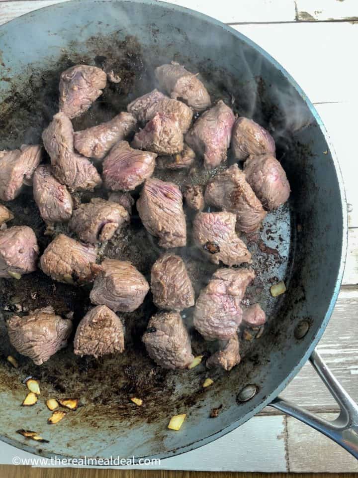 stewing beef frying in pan