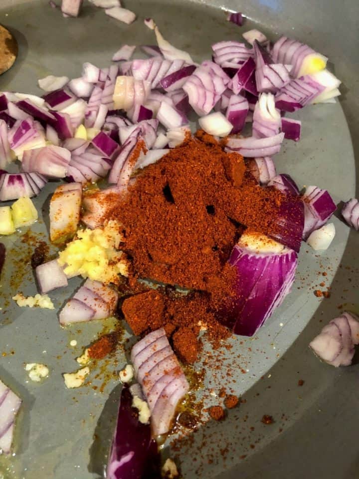 red onion garlic chilli powder in frying pan