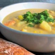 smoked haddock and prawn chowder in bowl next to loaf crusty bread