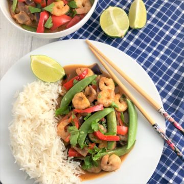prawn red thai curry with white rice plated with chopsticks to side