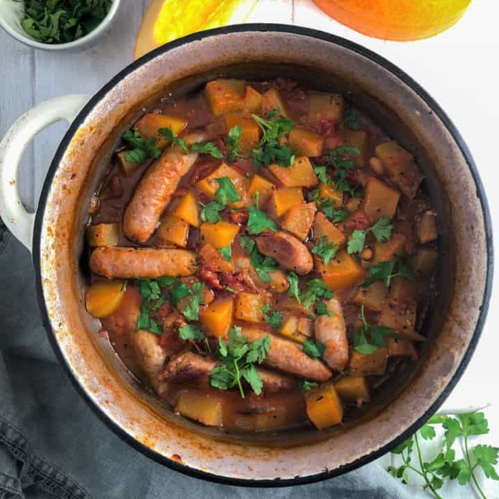 sausage and pumpkin casserole in dish topped with fresh parsley
