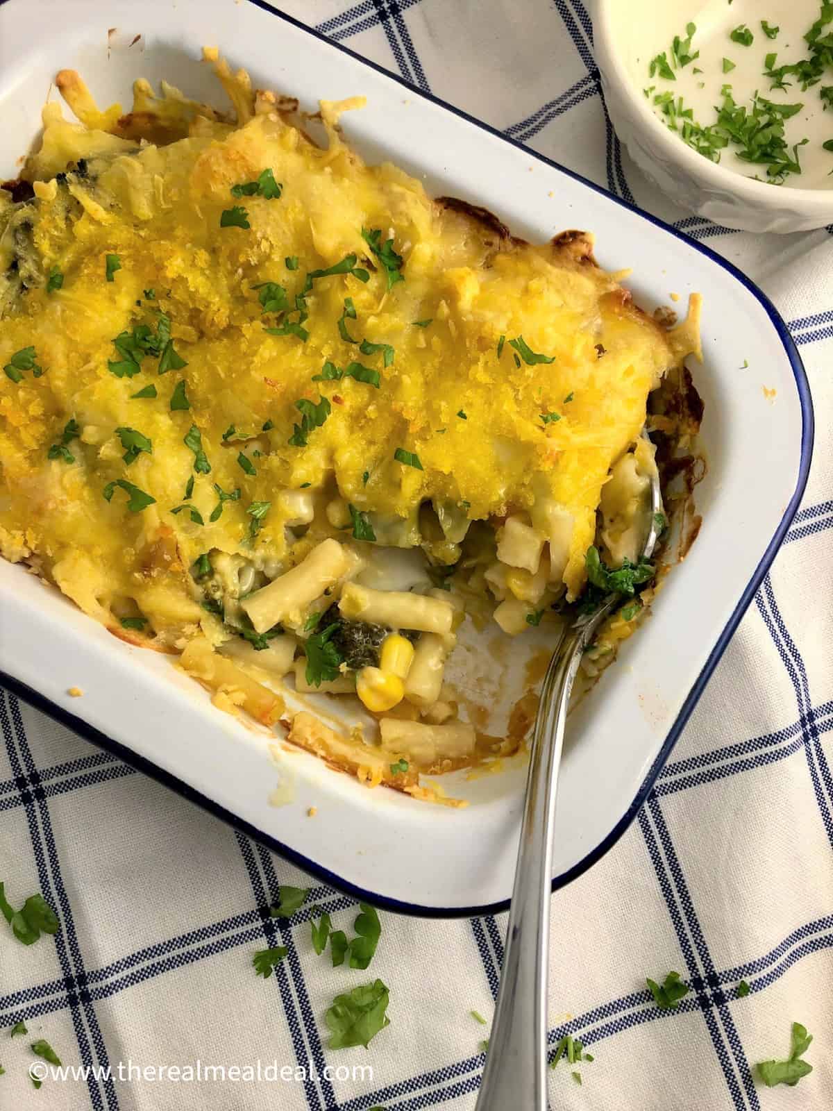 Vegan Mach and Cheese baked in a dish topped with fresh parsley