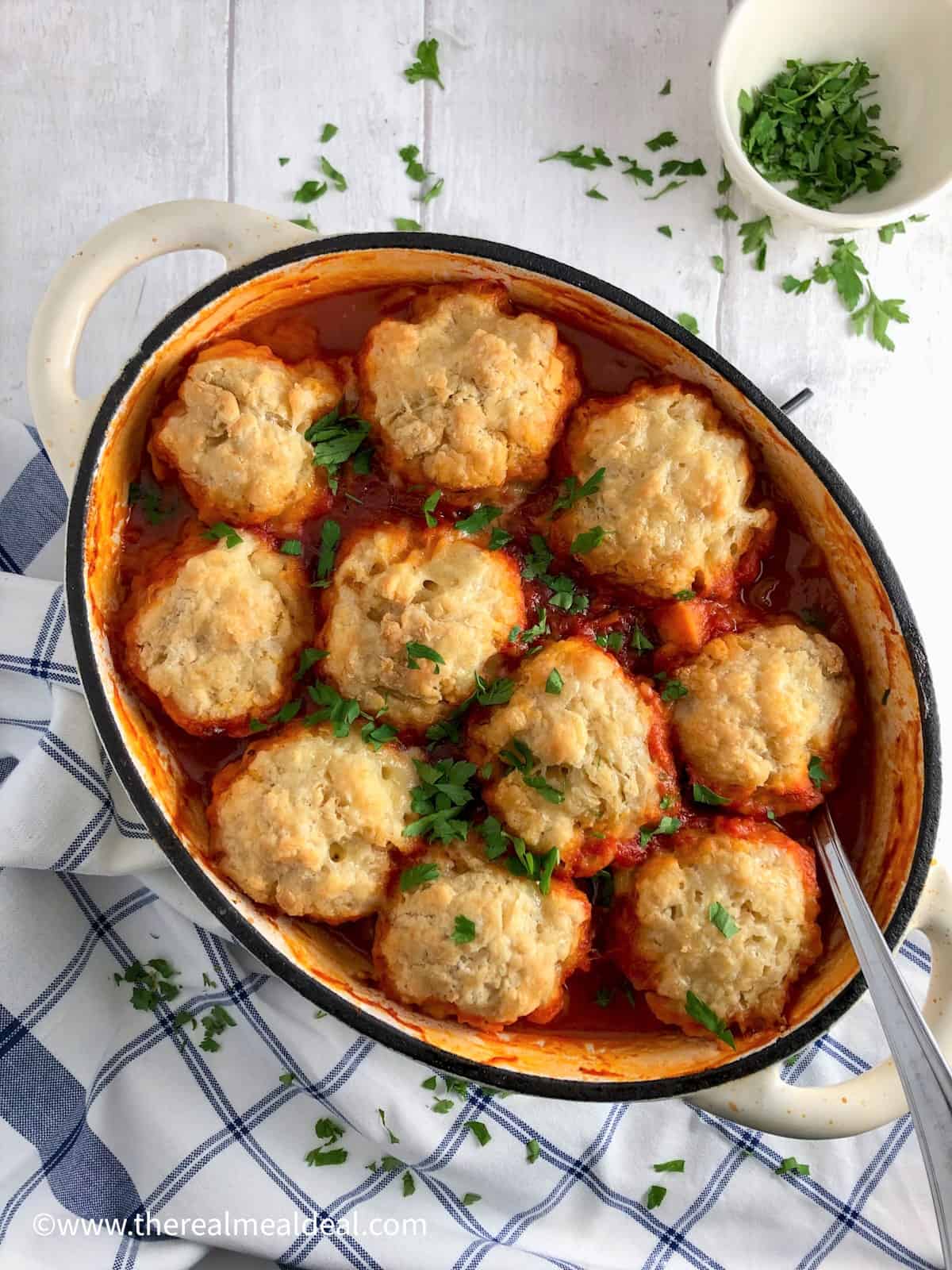 winter vegetable casserole with vegan dumplings topped with fresh parsley.
