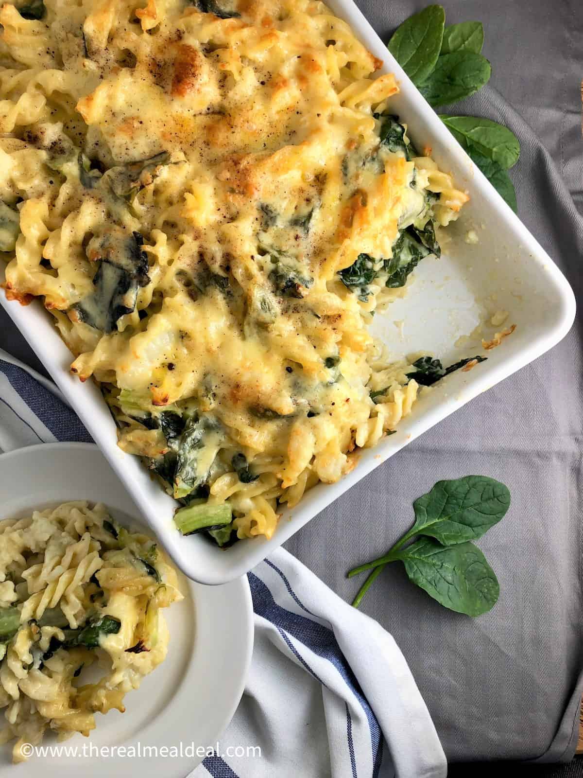 cauliflower and spinach cheese pasta dish with one portion on plate to side