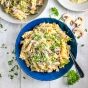 creamy chicken leek and mushroom pasta in bowl topped with fresh parsley