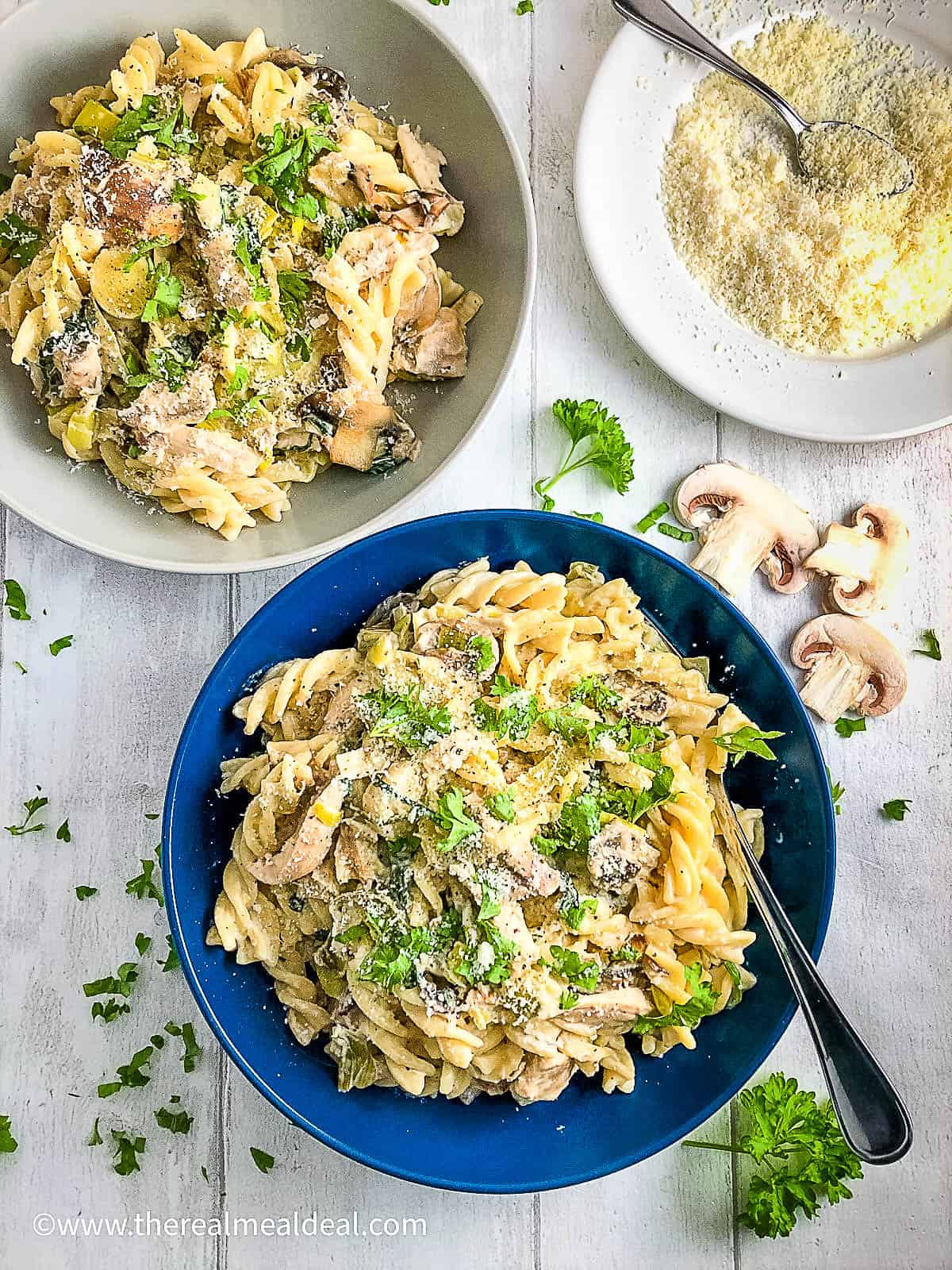 chicken leek and mushroom pasta in bowl topped with fresh parsley