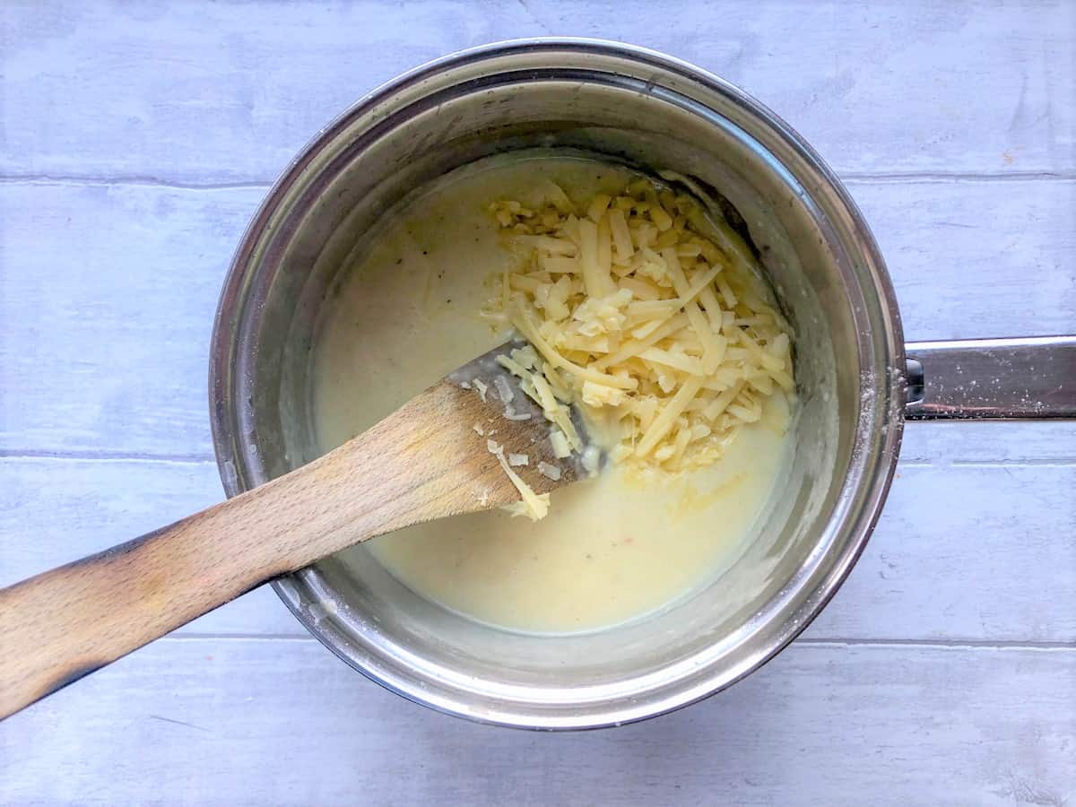 cheese sauce in pan with grated cheese added