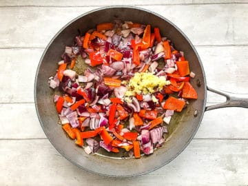 red onion red pepper ginger and garlic in frying pan.