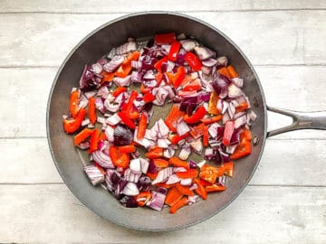 red onion and red pepper in pan