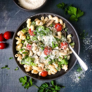creamy vegetable pasta in bowl topped with parmesan cheese