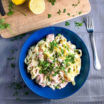 bowl of creamy salmon pasta with creme fraiche no cream topped with parsley and lemon zest